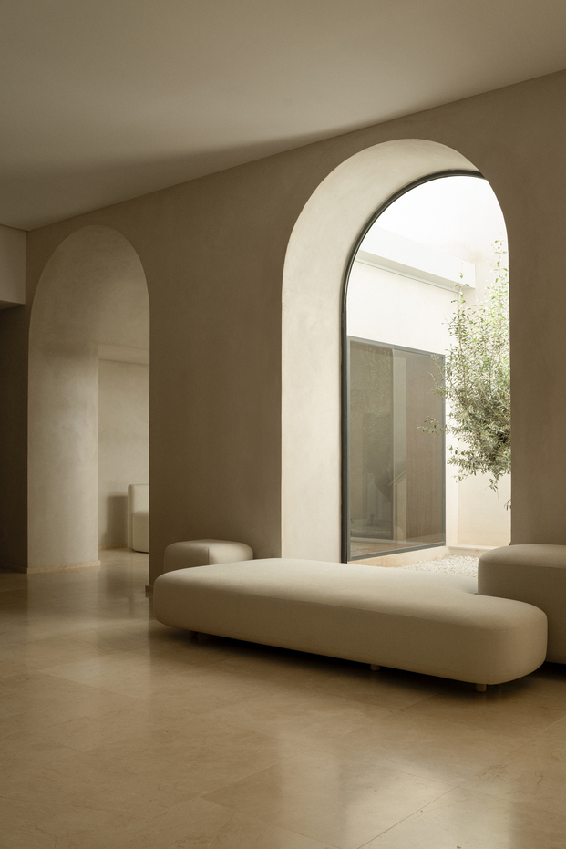 Arched interior opening with a large frameless glass window